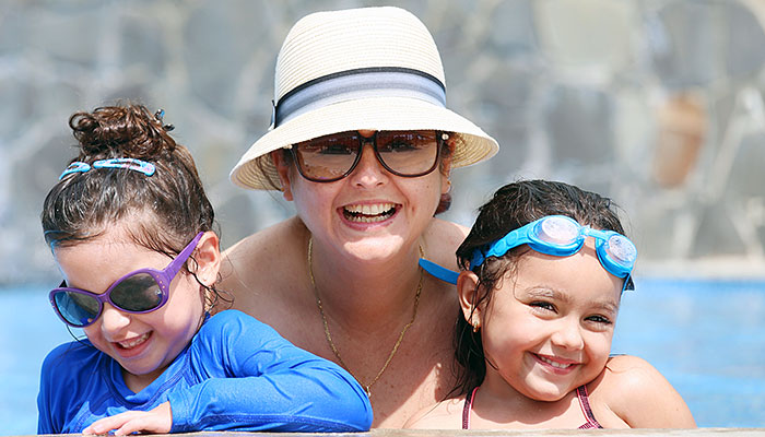 En glad kvinna med två barn som badat