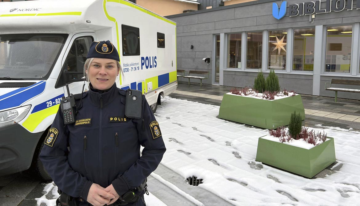 Kommunpolis Ida Hasselroth står framför polisens mobila kontor på Bibliotekstorget i Kil. Snö på marken.