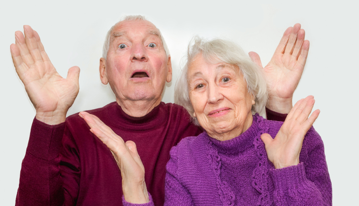 Två glada seniorer sträcker upp händerna 
