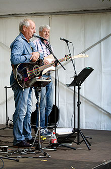 två män med gitarrer på scen