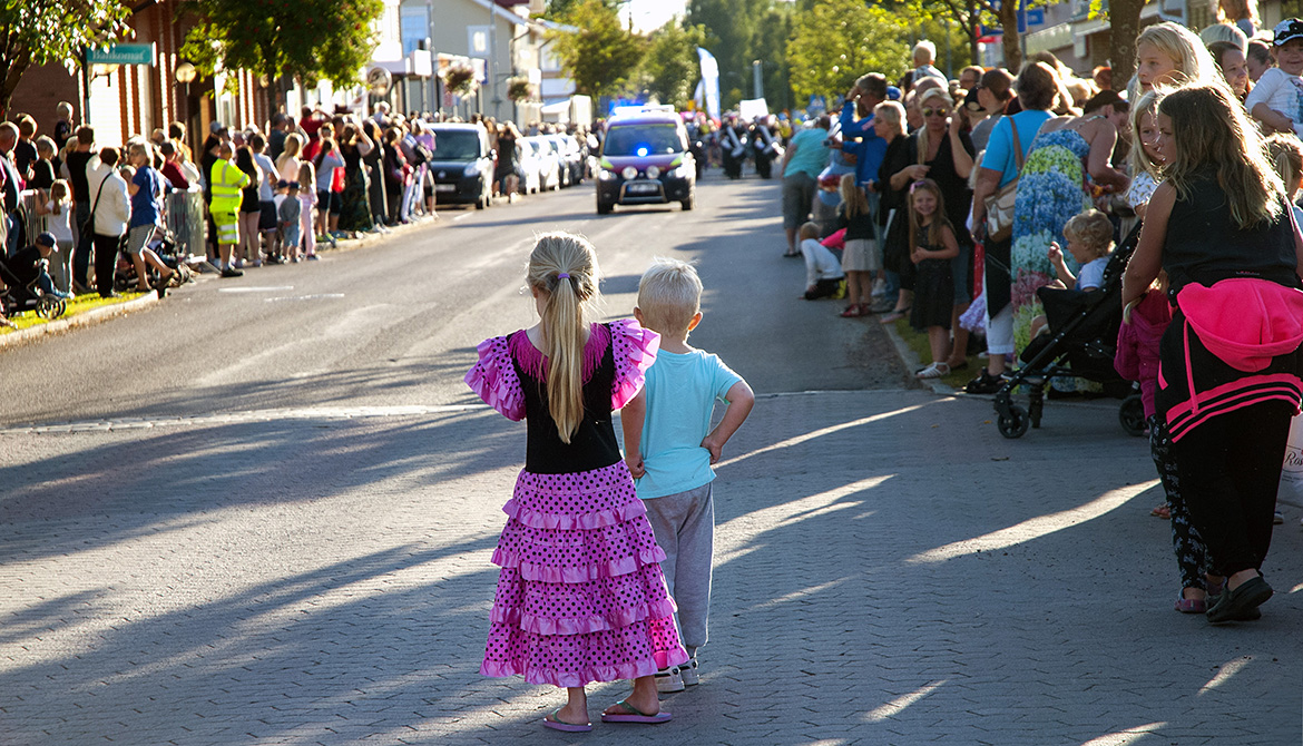 Flicka och pojke står på gatan och väntar på paraden