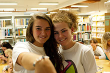 två unga kvinnor visar ett armband