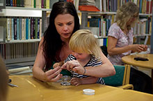 kvinna hjälper ett barn med pärlor