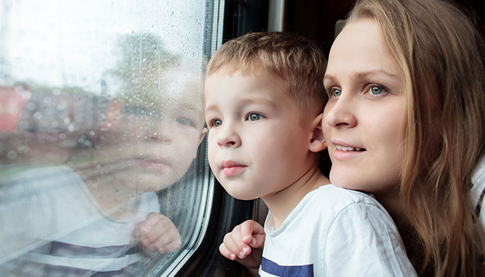 Två personer tittar ut genom ett tågfönster.