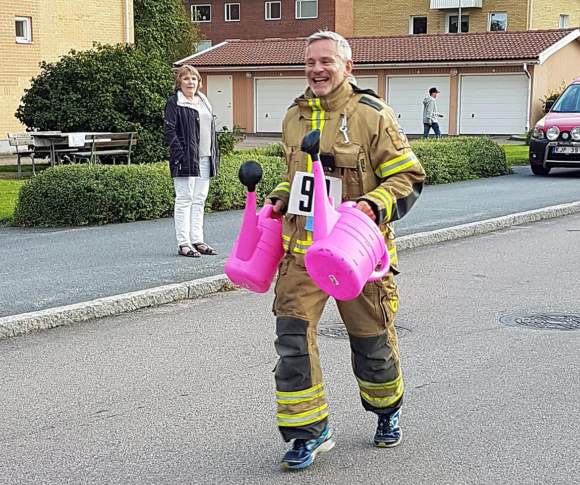 Brandman springer med rosa vattenkannor