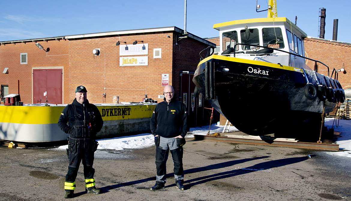 Lars Berg och Per Berg två framför dykbåt och annan utrustning.