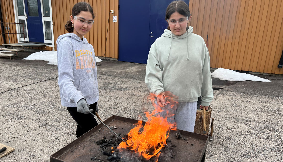 Nasrin Sadeqi och Dana Ghalib går i årskurs 5A på Sannerudsskolan och har en lektion i smide. Här håller de varsin järnstång över öppen eld.